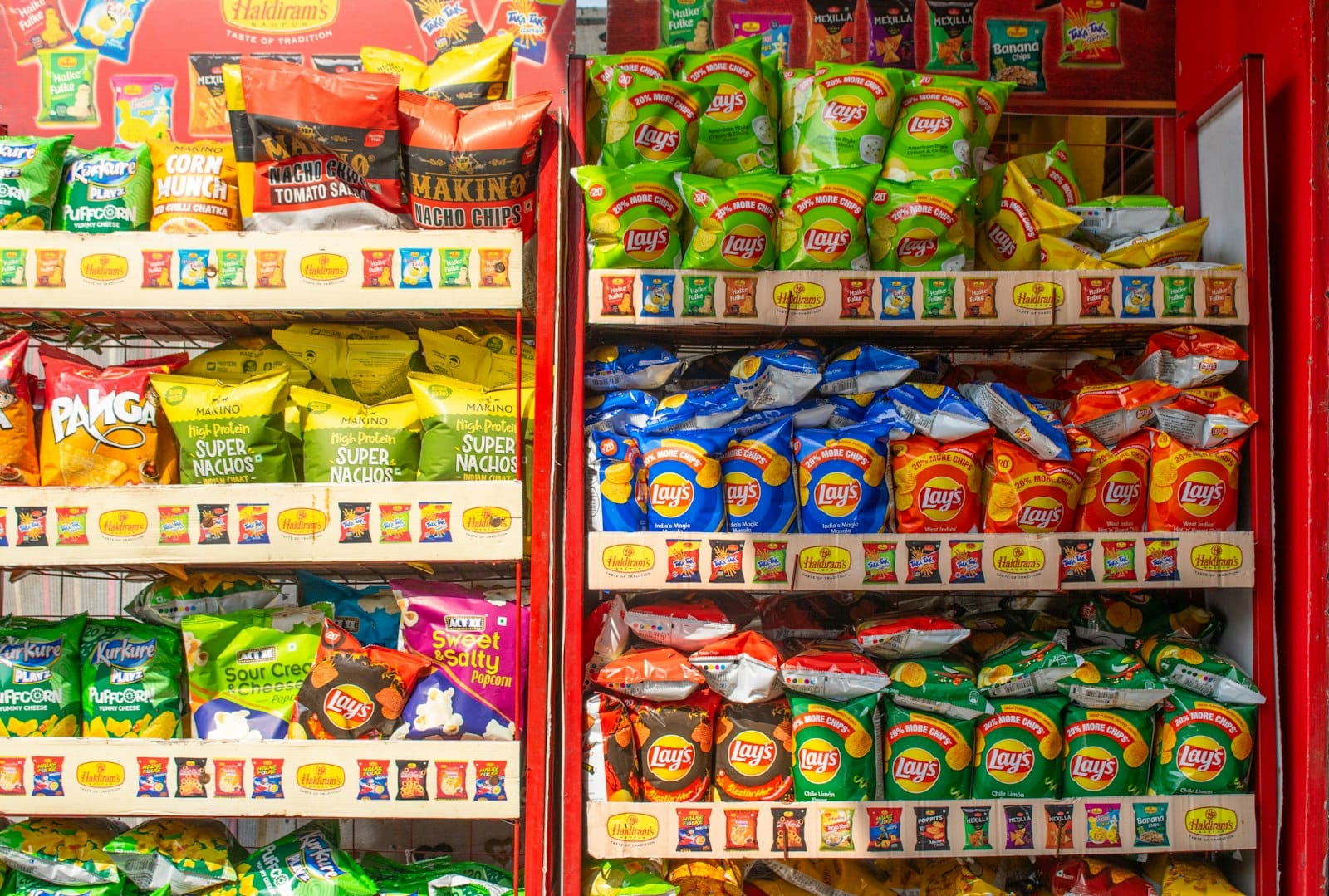 Densely stacked shelves of packaged snacks in an Indian shop